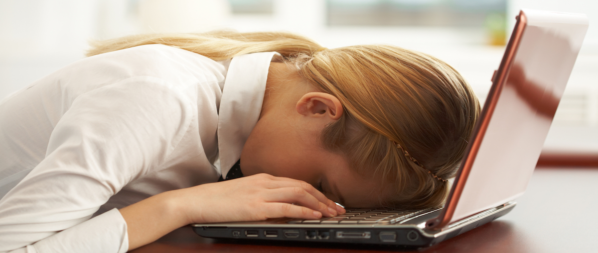 Image of very tired businesswoman or student with her face on keyboard of laptop